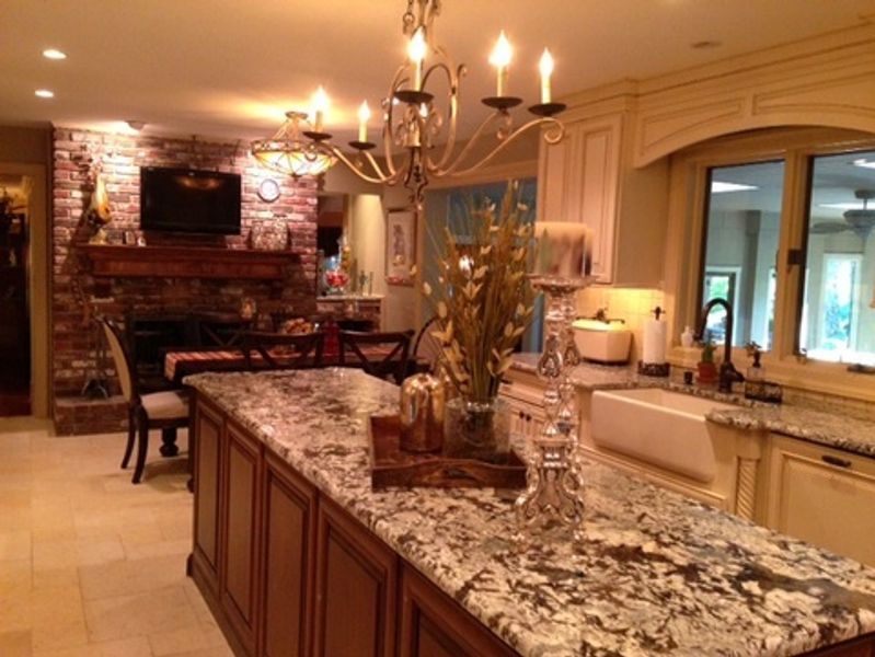 A kitchen with granite counter tops and a chandelier