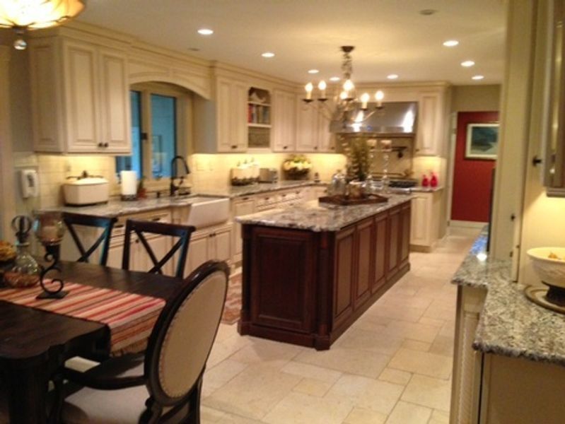 A kitchen with white cabinets and a large island