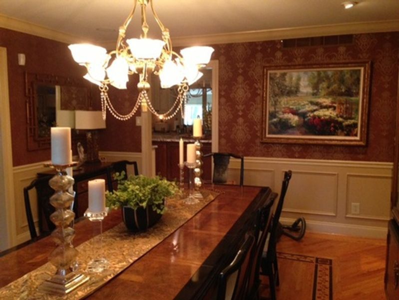 A dining room with a long table and a chandelier