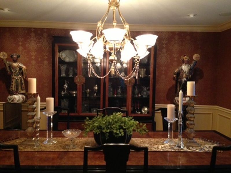 A dining room table with candles and a chandelier