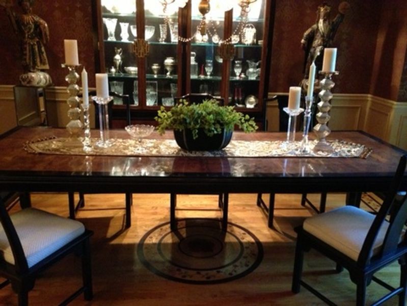 A dining room table with candles and a plant on it