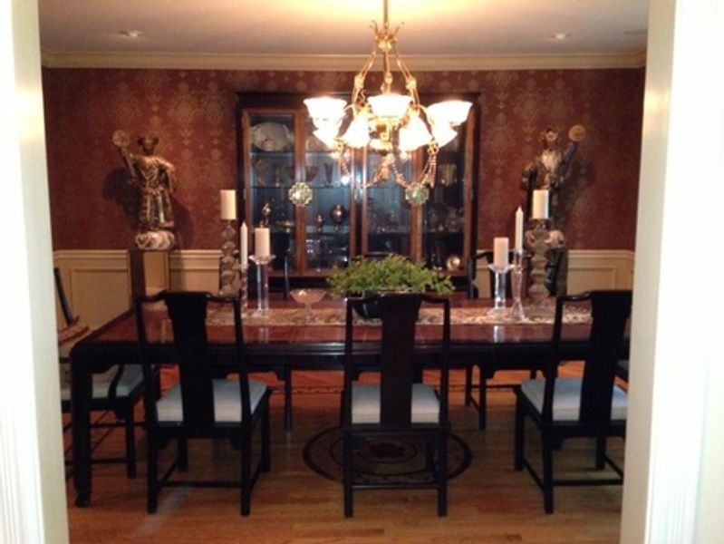 A dining room with a table and chairs and a chandelier