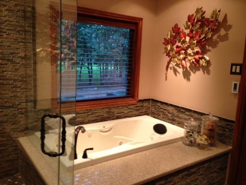 A bathroom with a jacuzzi tub and a window
