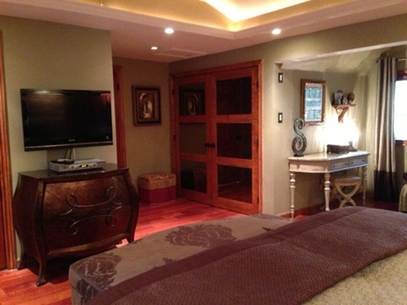 A bedroom with a large bed and a flat screen tv