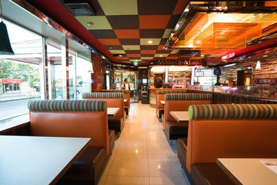 A restaurant with tables and booths and a checkered ceiling