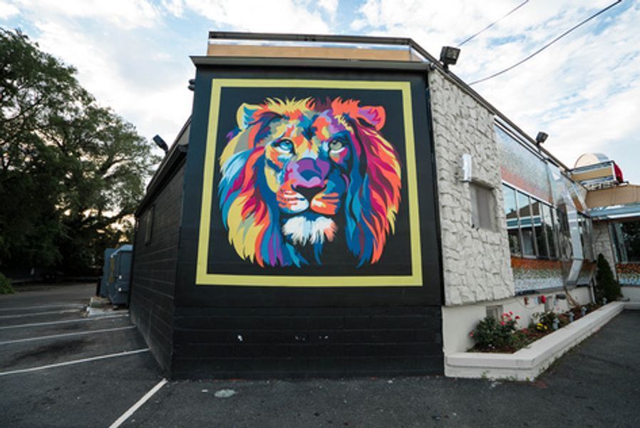 A colorful painting of a lion on the side of a building