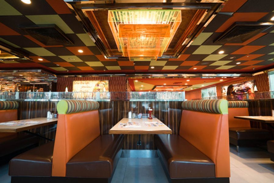 A restaurant with tables and benches and a checkered ceiling