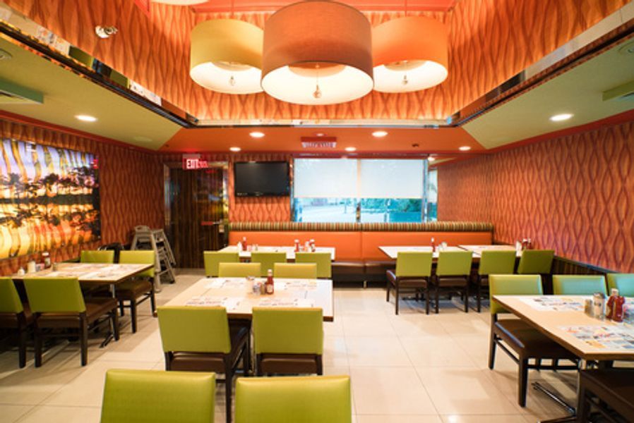 A large dining room with tables and chairs in a restaurant