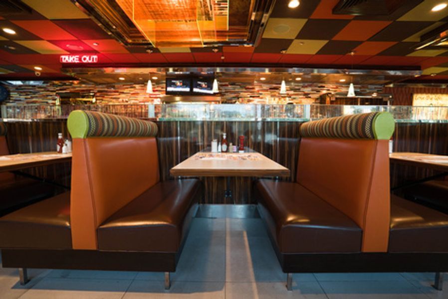 A restaurant booth with a table and a sign that says take out