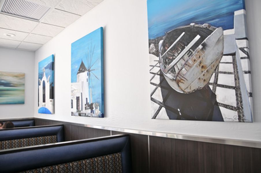 A restaurant with a row of booths and paintings on the wall
