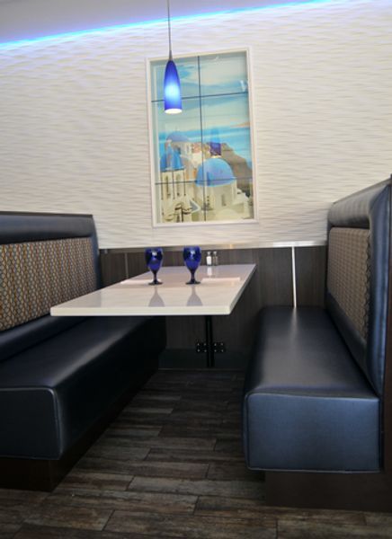 A restaurant booth with a table and two wine glasses