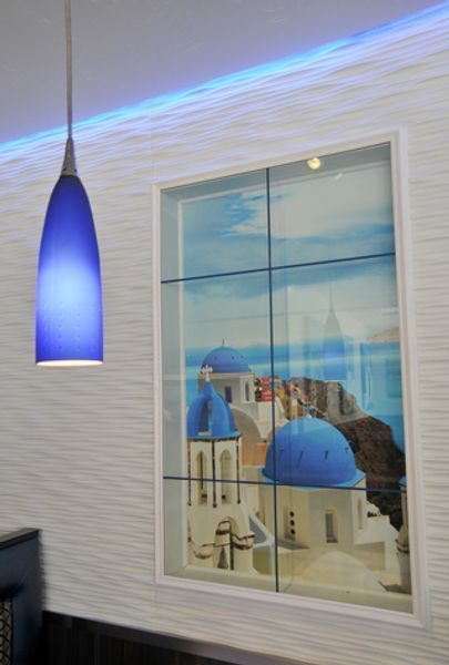 A picture of santorini is hanging on a wall