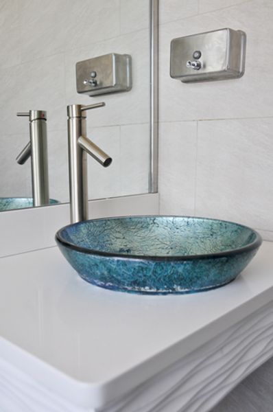 A bathroom with a blue sink and a mirror