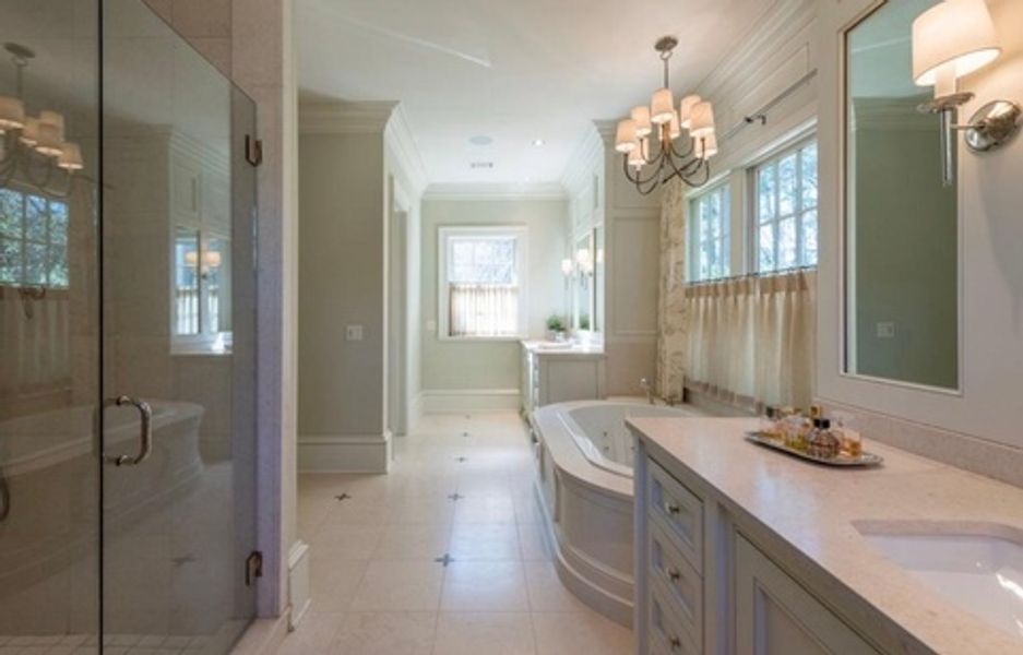 A bathroom with a tub, sink, and shower