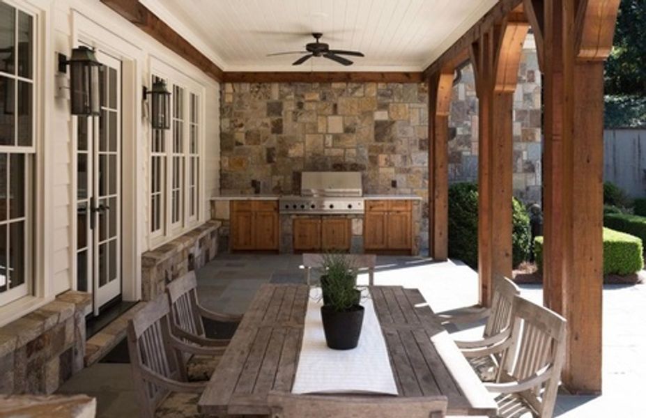 A patio with a table and chairs and a ceiling fan