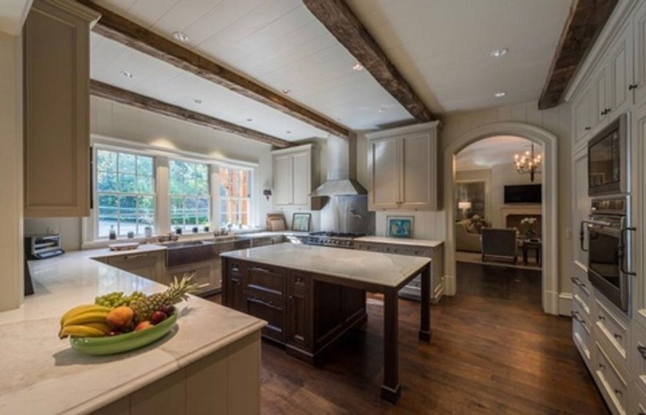 A kitchen with a large island and a bowl of fruit on the counter