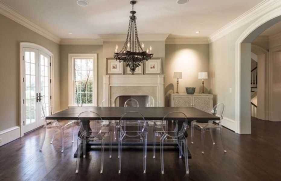 A dining room with a long table and clear chairs