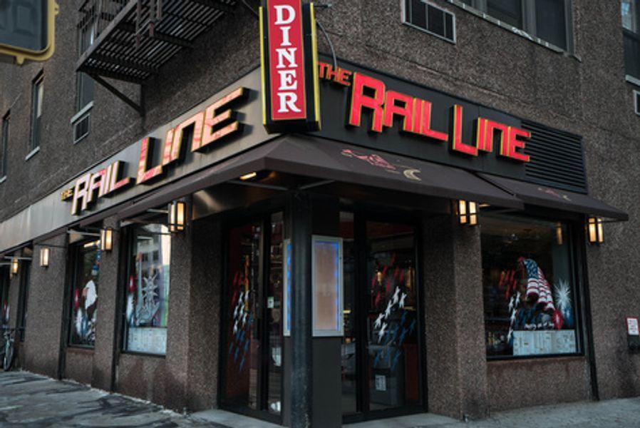 A diner called the rail line is on the corner of a building