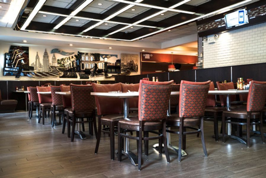 A restaurant with tables and chairs and a mural on the wall