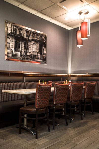 A restaurant with tables and chairs and a picture on the wall