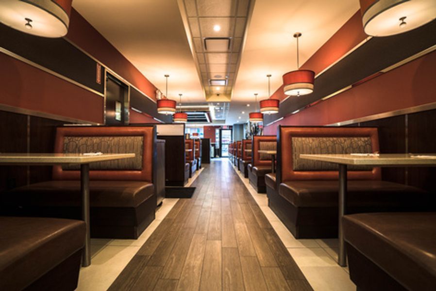A long hallway in a diner with tables and booths