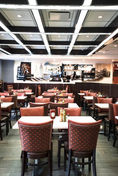 A restaurant with tables and chairs and a mural on the wall