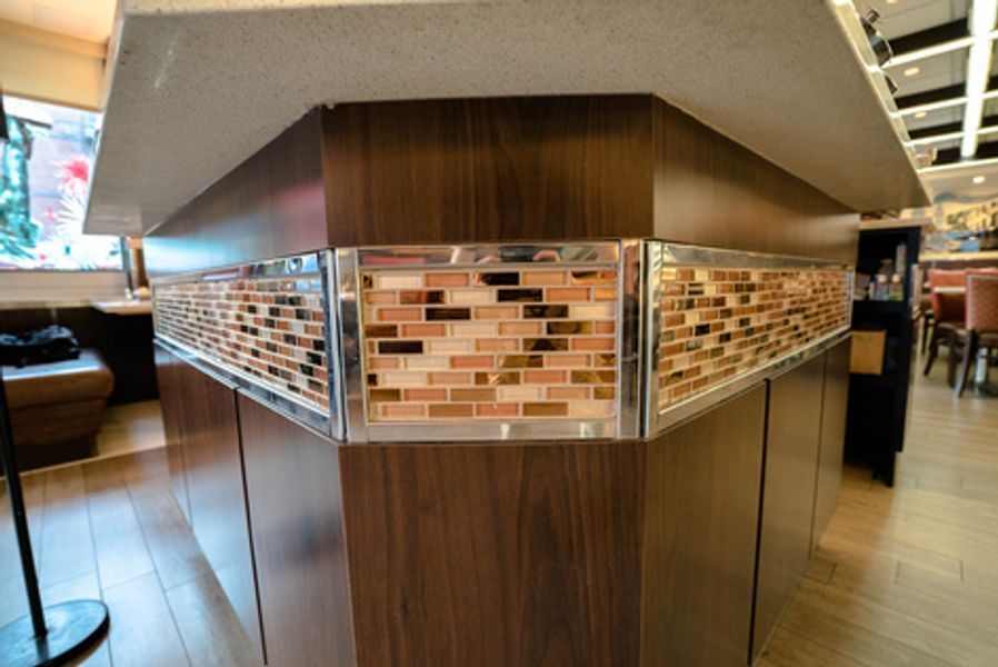 A restaurant with a wooden counter top and a tiled wall