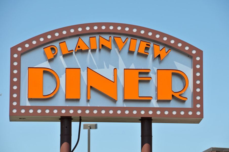 A sign for plainview diner against a blue sky