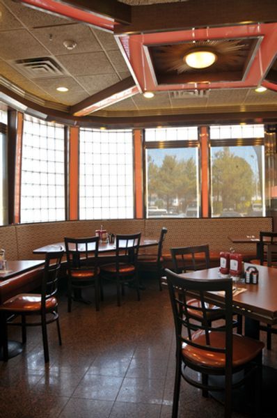 The inside of a restaurant with tables and chairs