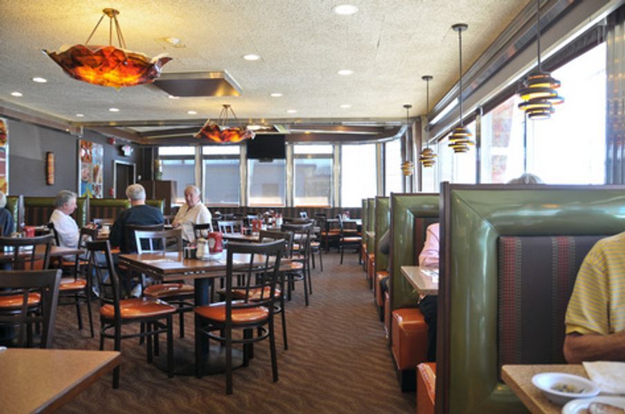 A restaurant with people sitting at tables and booths