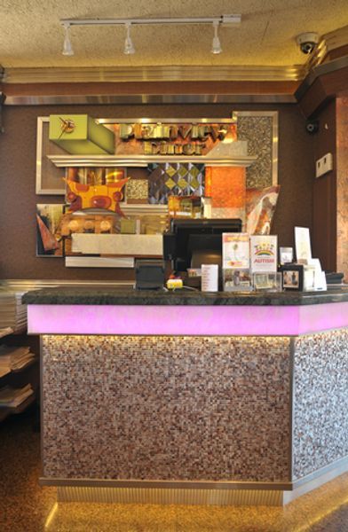 A pink counter in a restaurant with a computer on it