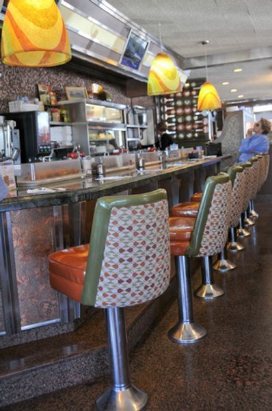 A diner with a row of chairs and a counter