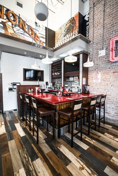 A restaurant with a long bar and wooden floors