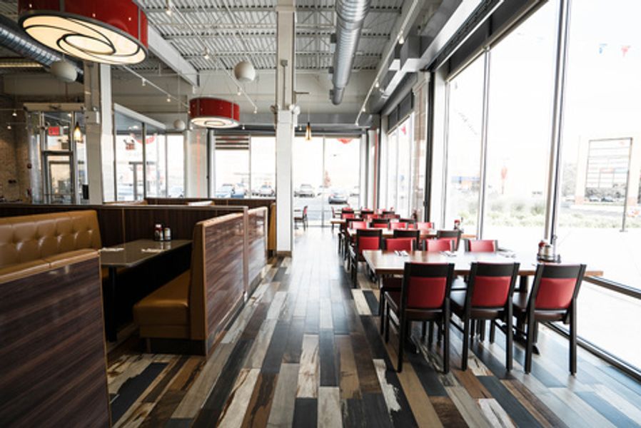 A restaurant with tables and chairs and a large window
