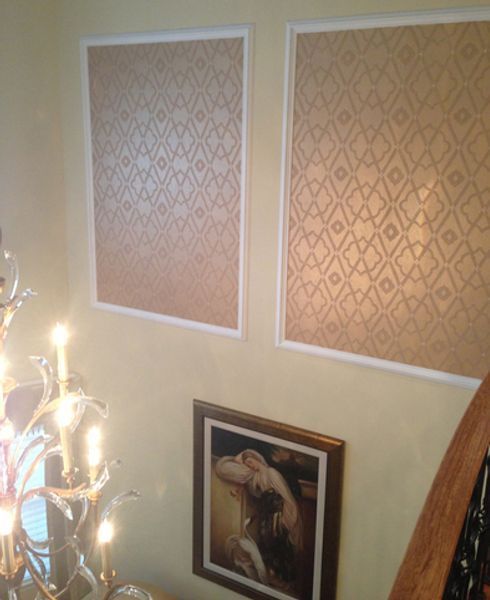 A picture of a woman is hanging on a wall next to a chandelier