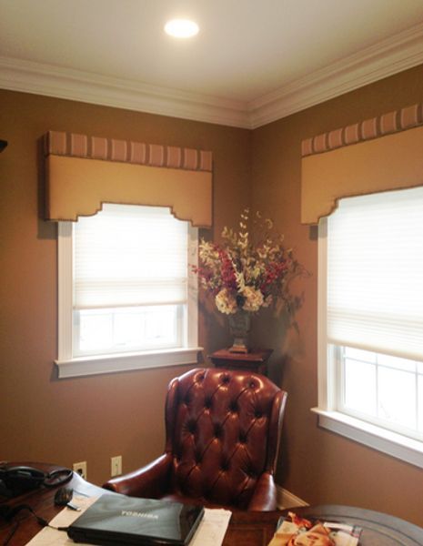 A brown leather chair sits at a desk in front of a window