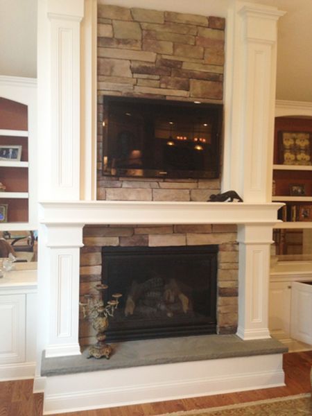 A living room with a fireplace and a flat screen tv