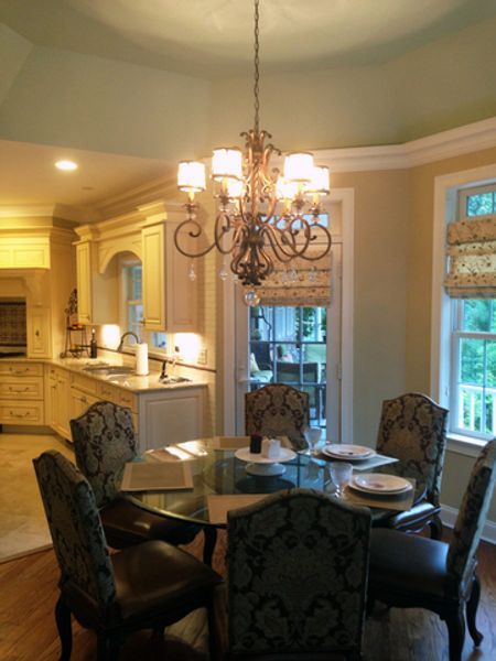 A dining room with a table and chairs and a chandelier