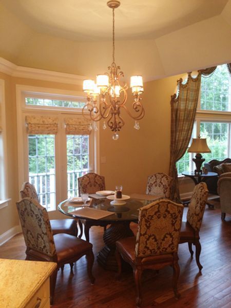 A dining room with a table and chairs and a chandelier