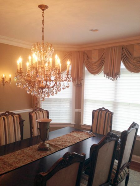 A dining room with a long table and chairs and a chandelier