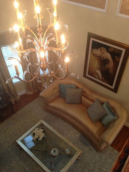A living room with a couch a coffee table and a chandelier