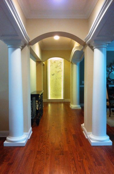 A hallway with columns and a picture on the wall