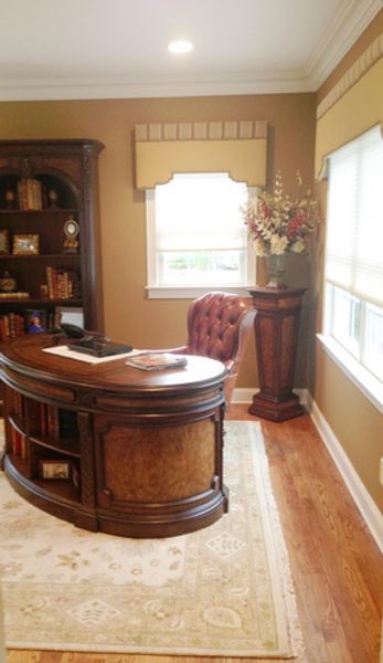 A home office with a desk and chair in front of a window