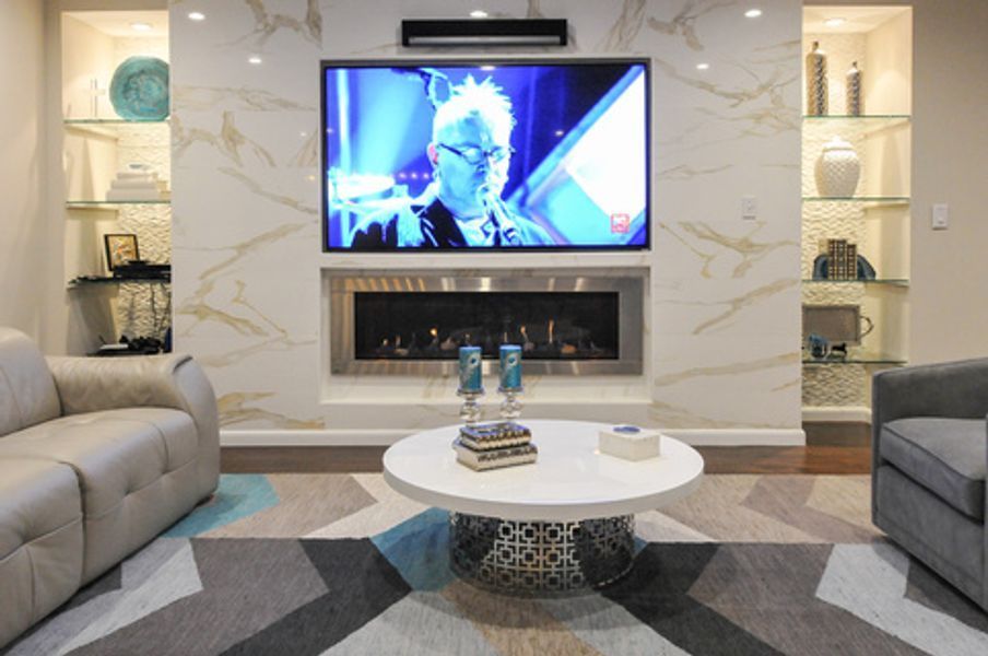 A living room with a fireplace and a flat screen tv