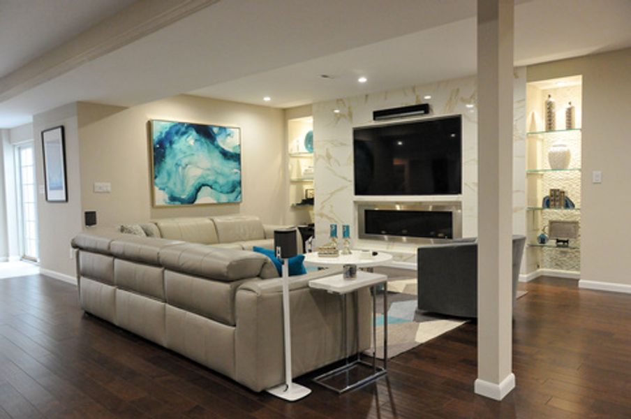 A living room with a large sectional couch and a flat screen tv