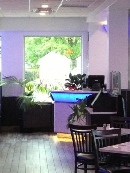 A restaurant with tables and chairs in front of a window