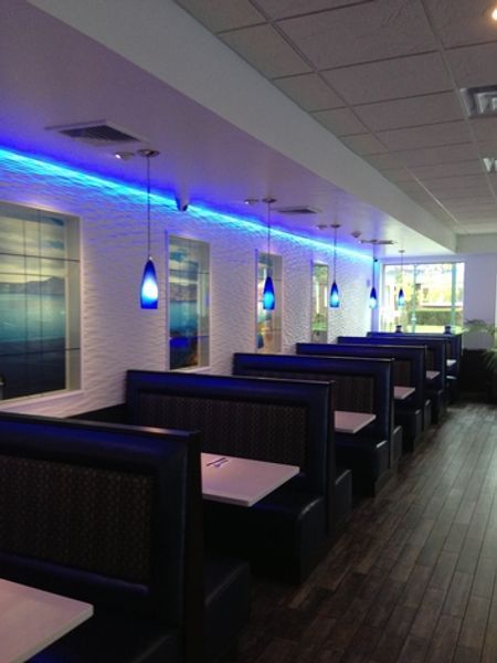 A restaurant with blue lights hanging from the ceiling
