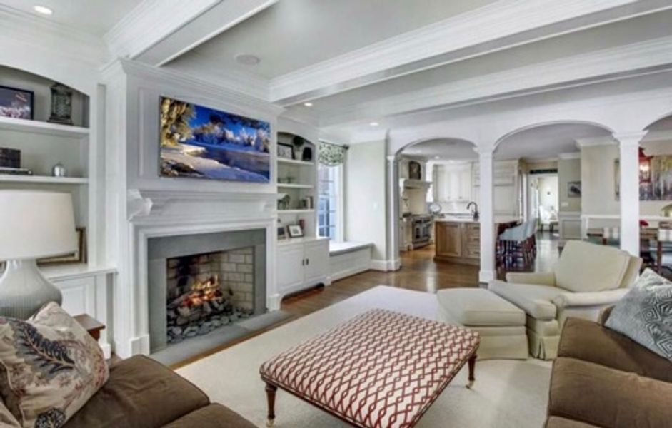 A living room with a fireplace and a flat screen tv on the wall