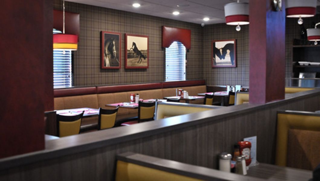 The inside of a restaurant with tables and chairs