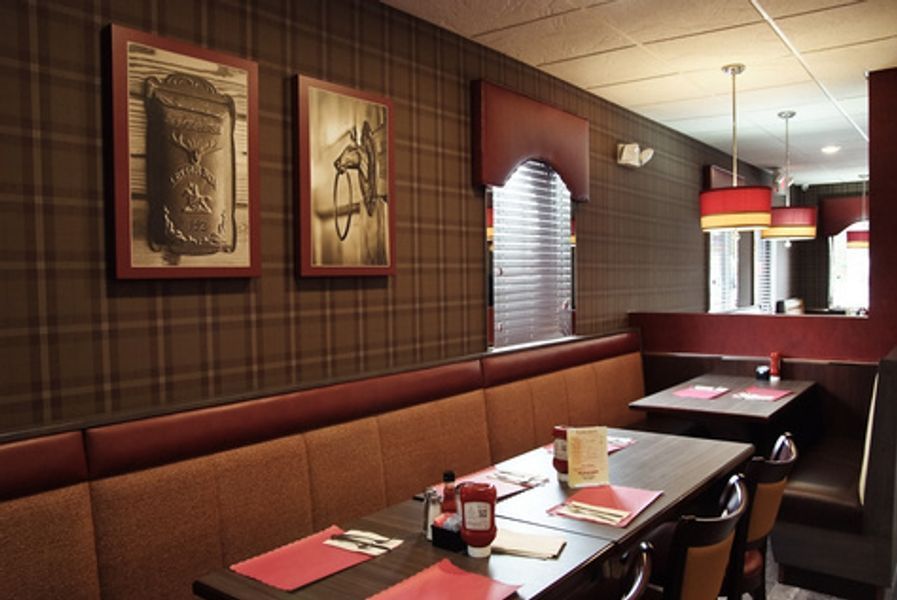 A restaurant with tables and chairs and pictures on the wall